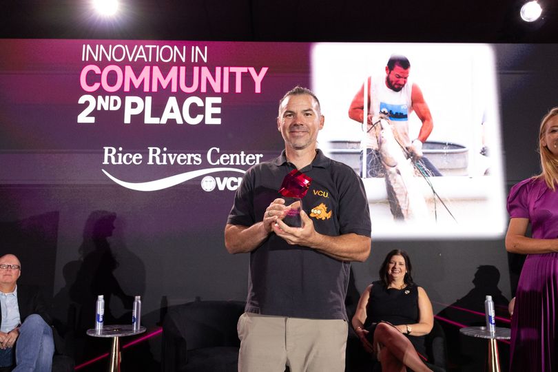 Dr. Matt Balazik on stage accepting a T-Mobile Unconventional Award, holding the award