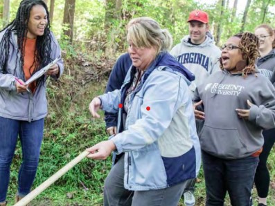 Casey Johnson (left), a Graduate Student in VCU Life Sciences, assists participating district teachers in stream measurements at the VCU Rice Rivers Center.