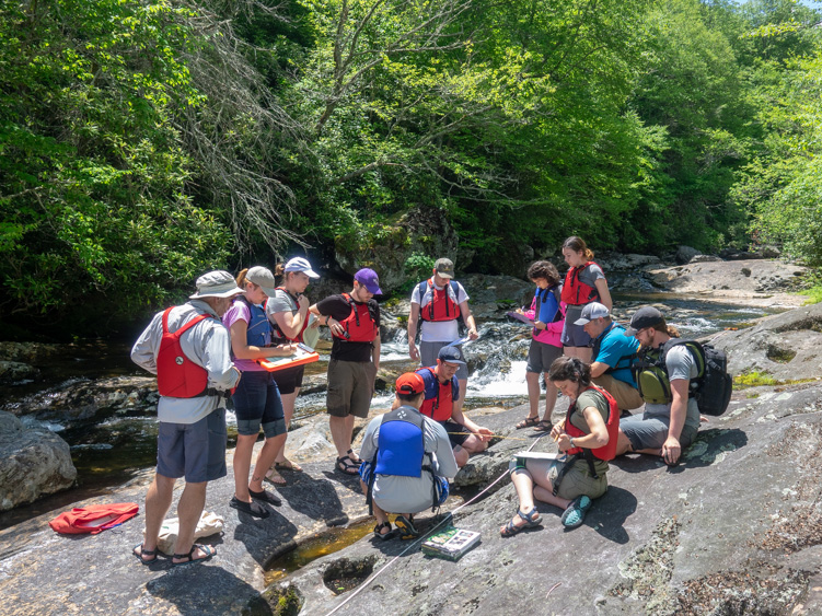 A group of VCU students on the shore of a riverbank